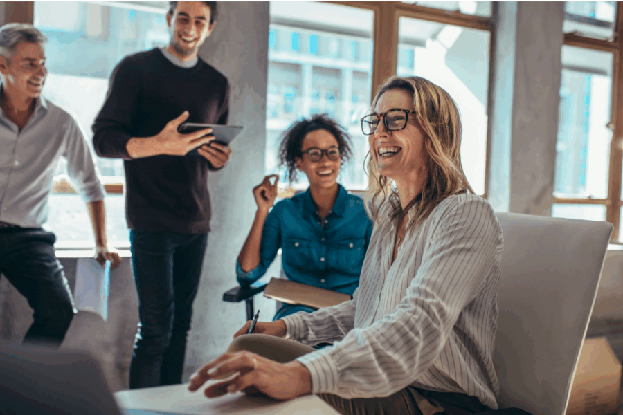 Group of professionals engaged in a lively brainstorming session around a table, with notes and laptops visible—representing creativity, teamwork, and problem-solving.